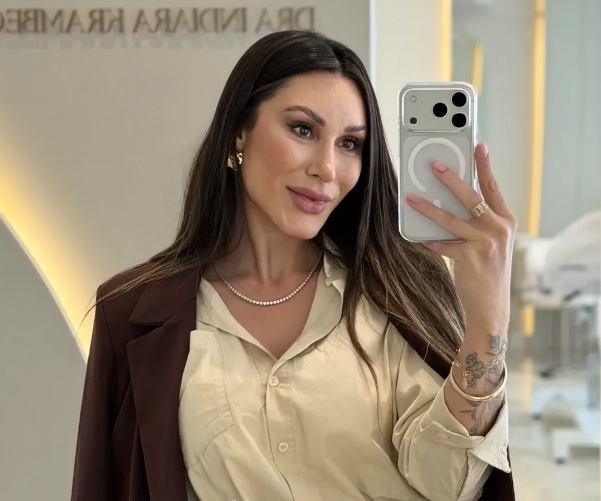 Dra. Indiara Krambeck em sua clínica, em Balneário Camboriú, de blazer, sorrindo